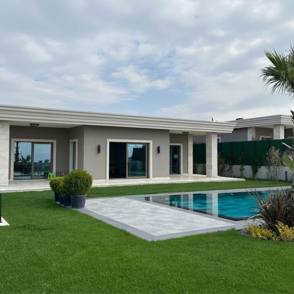 Tek katlı modern villa mimarisi, yüzme havuzu ve geniş bahçe peyzaj tasarımı.